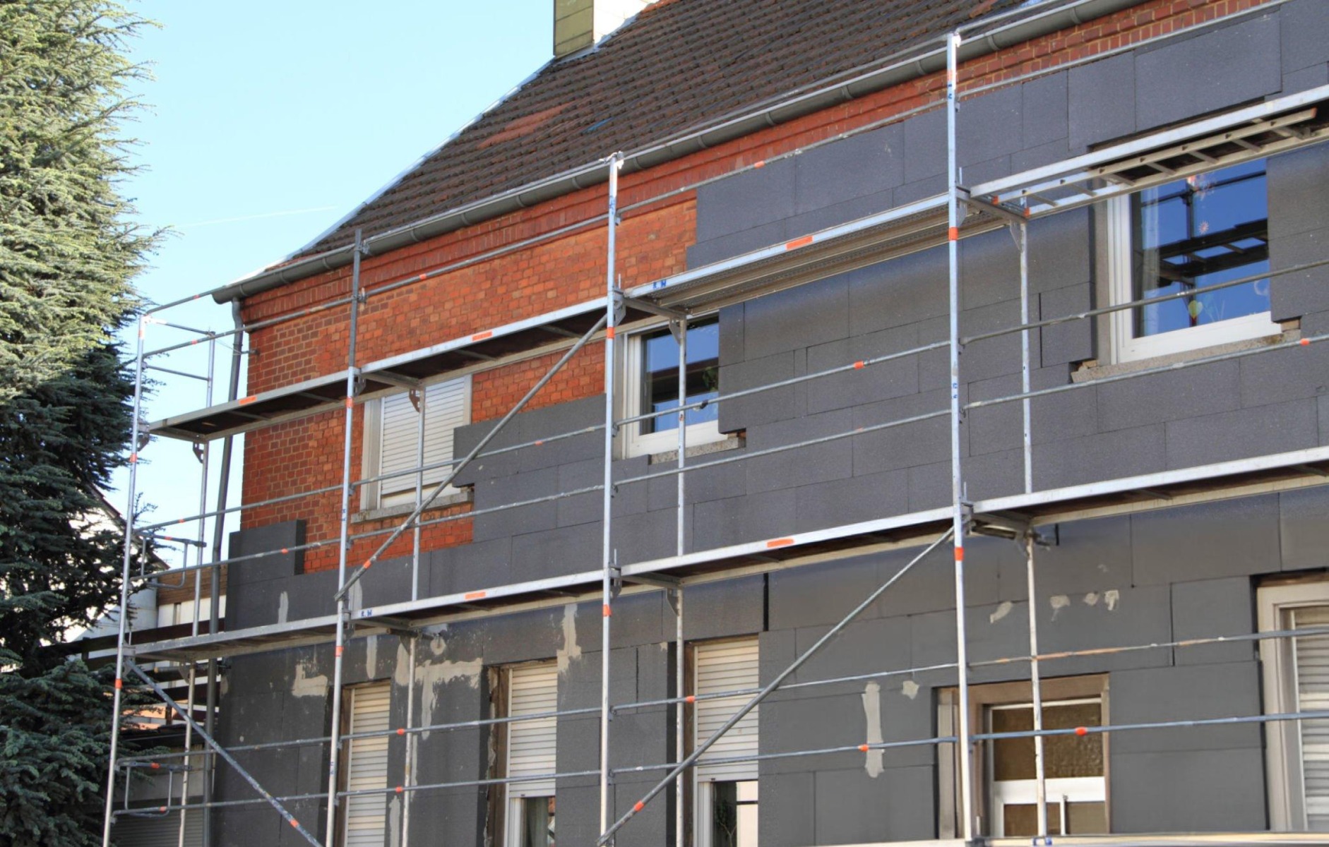 Haus mit Gerüst und Fassadendämmung