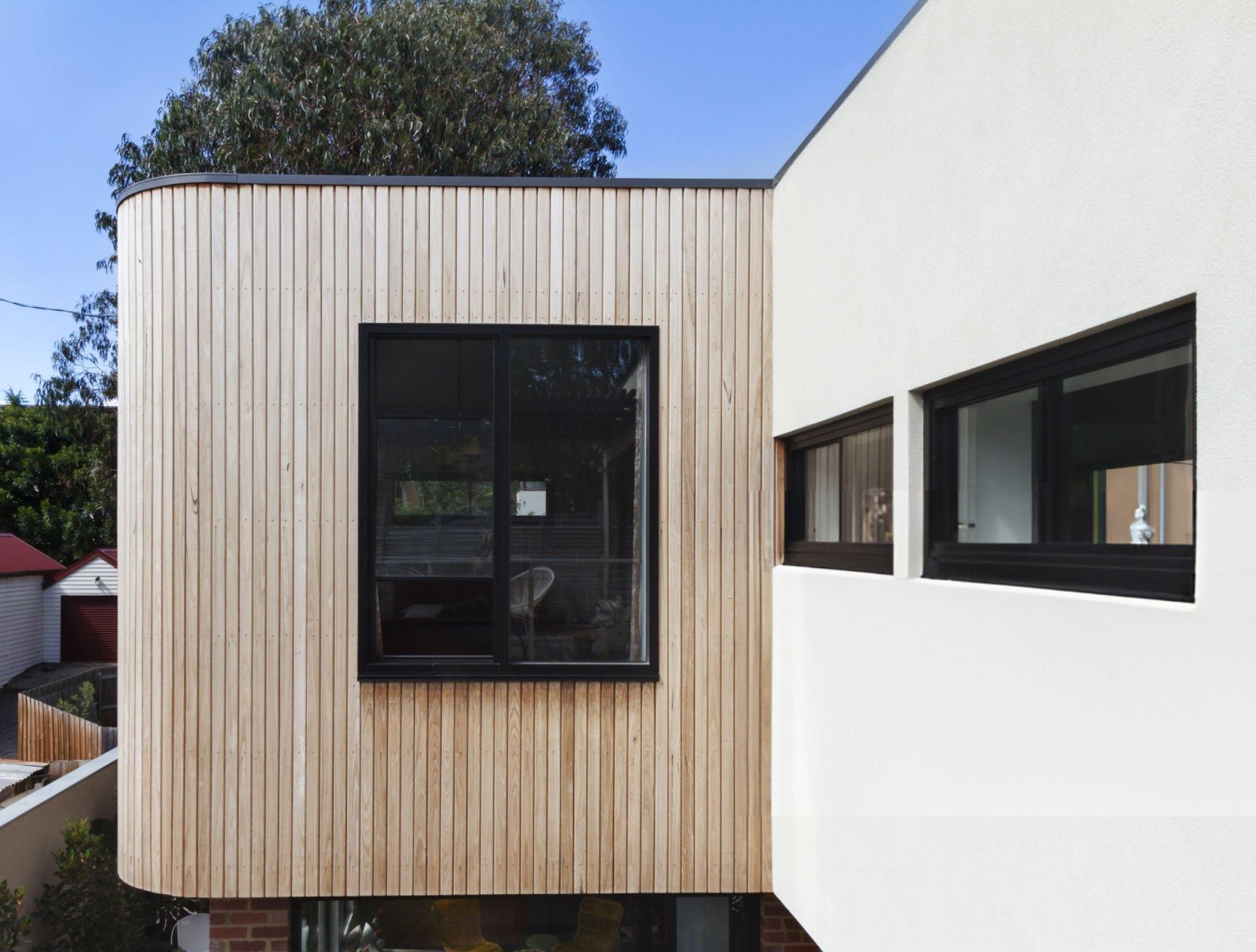 Holzverkleidung an verputztem Haus